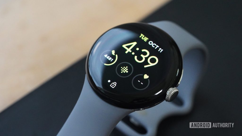 A Google Pixel Watch rets on a yoga mat, displaying a user's activity stats on a default watch face.